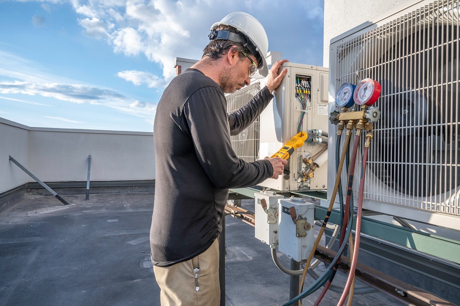 HVAC technician working on mini split Professional HVAC technician taking an amperage reading on a mini-split ductless air conditioning system.